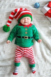 Photo of Cute baby in Christmas costume lying on blanket
