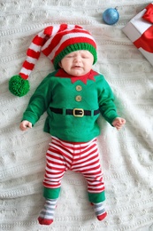 Cute baby in Christmas costume lying on blanket