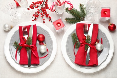 Festive table setting with beautiful dishware and Christmas decor on white background, flat lay