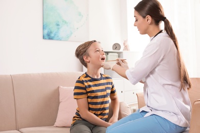 Photo of Family doctor visiting ill child at home