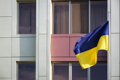 Photo of Ukrainian flag and modern building on background
