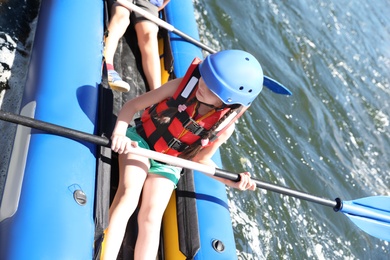 Little girl kayaking on river. Summer camp