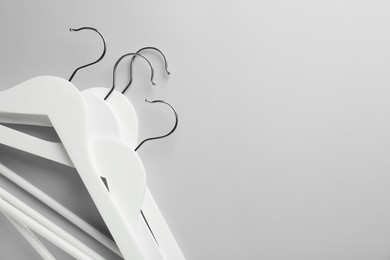 Photo of White hangers on light gray background, top view. Space for text