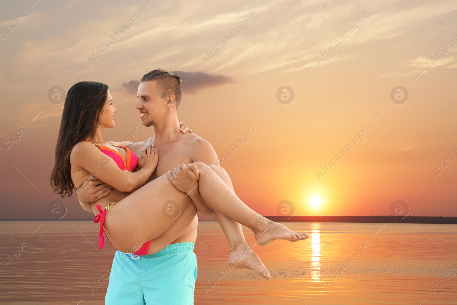 Photo of Young woman in bikini spending time with her boyfriend on beach. Lovely couple