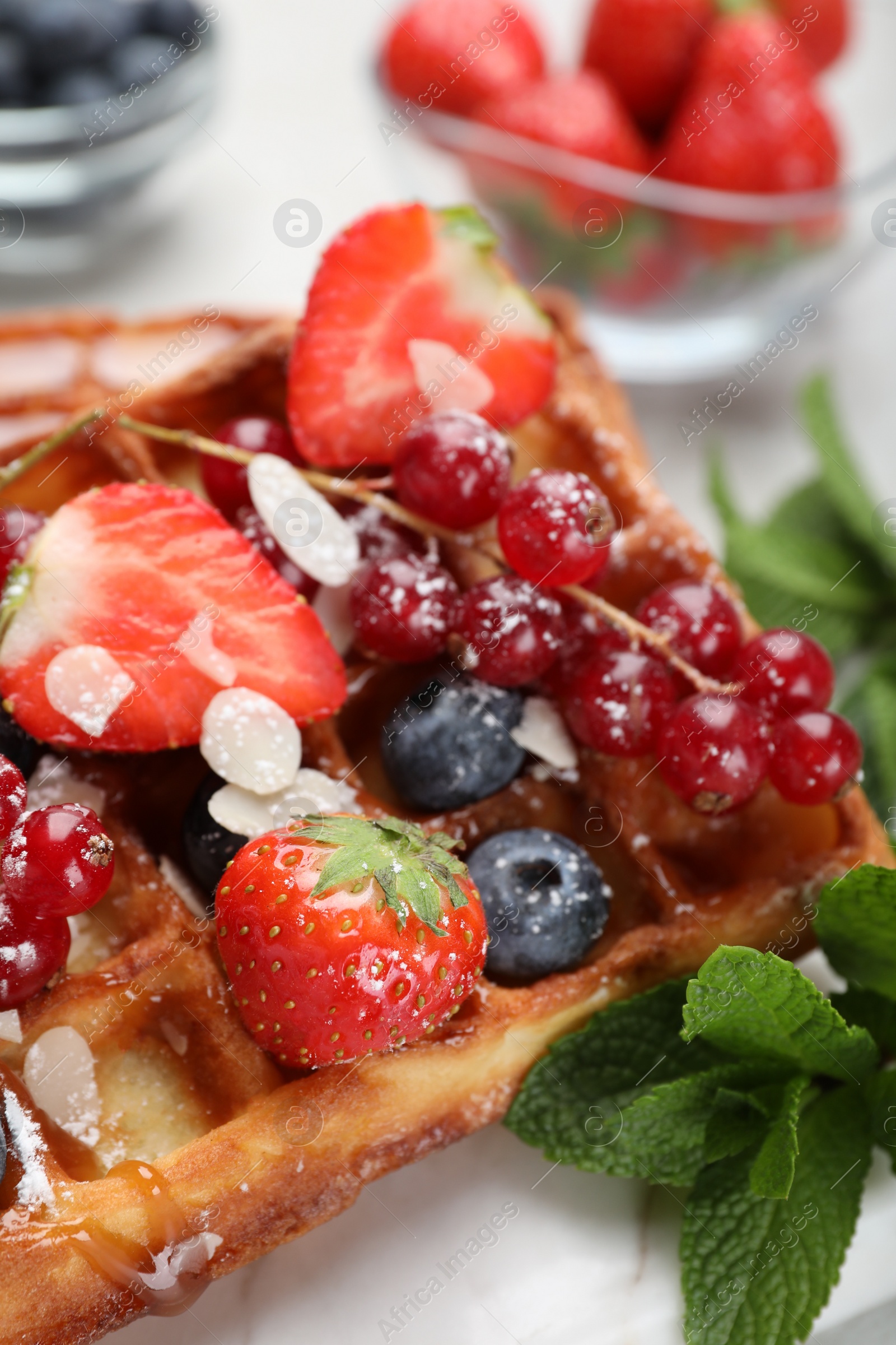 Photo of Delicious Belgian waffles, berries and caramel sauce on table, closeup