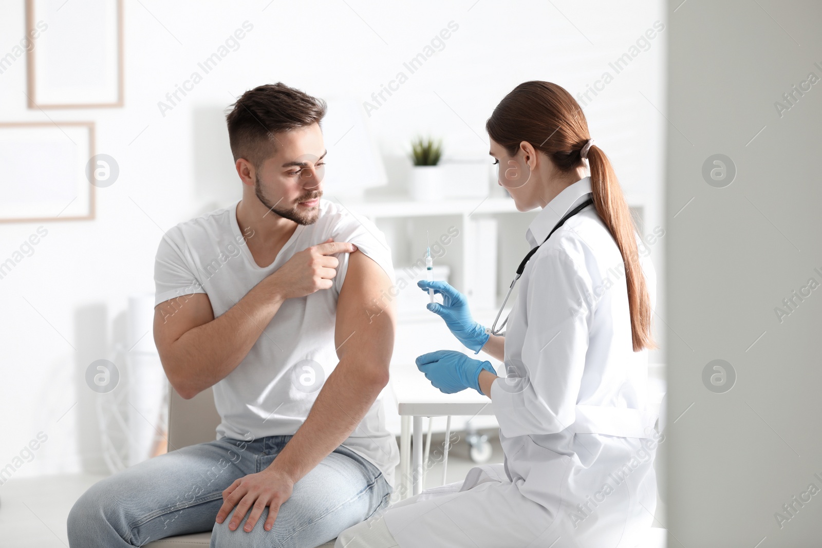 Photo of Doctor giving injection to patient in hospital. Vaccination concept