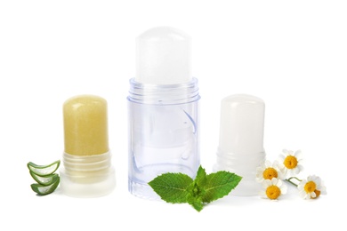 Photo of Natural crystal alum stick deodorants with chamomiles, mint and aloe on white background