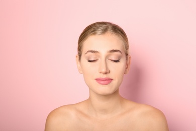 Photo of Portrait of young woman with beautiful natural eyelashes on color background