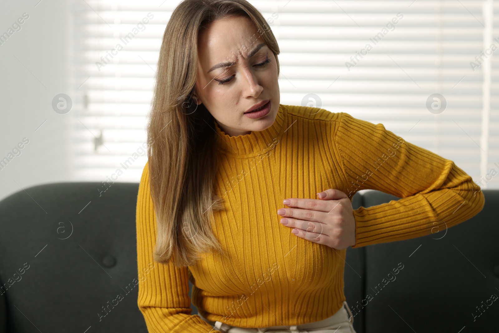 Photo of Mammology. Young woman doing breast self-examination at home