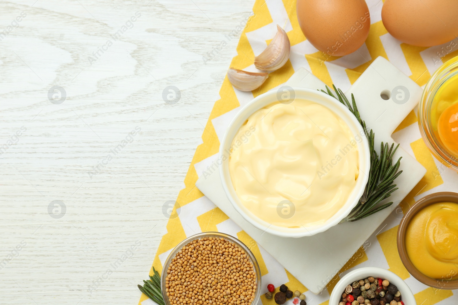 Photo of Delicious homemade mayonnaise, spices and ingredients on white wooden table, top view. Space for text