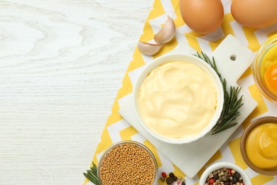 Photo of Delicious homemade mayonnaise, spices and ingredients on white wooden table, top view. Space for text