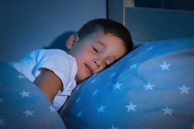 Cute little boy sleeping in comfortable bed