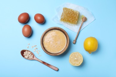 Homemade hair mask and ingredients on light blue background, flat lay