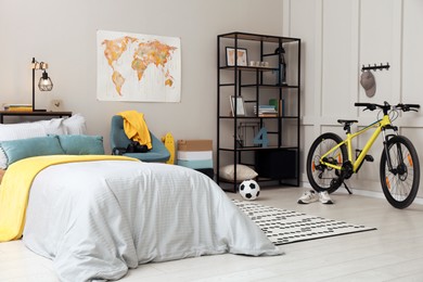 Stylish teenager's room interior with comfortable bed and sports equipment