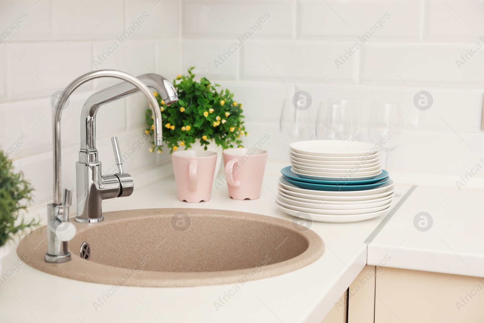 Photo of Clean dishes on counter near kitchen sink indoors