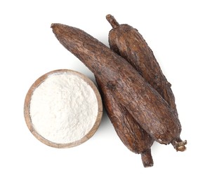 Photo of Bowl with cassava flour and roots isolated on white, top view