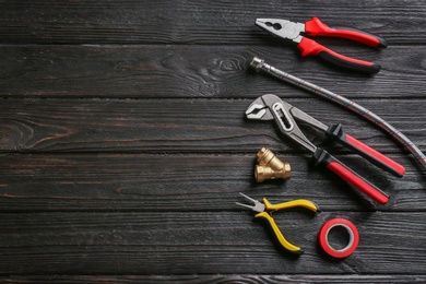 Photo of Flat lay composition with plumber's tools and space for text on wooden background