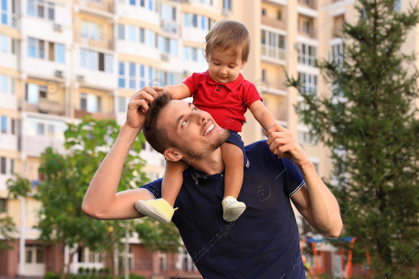 Photo of Father with adorable little baby outdoors. Happy family