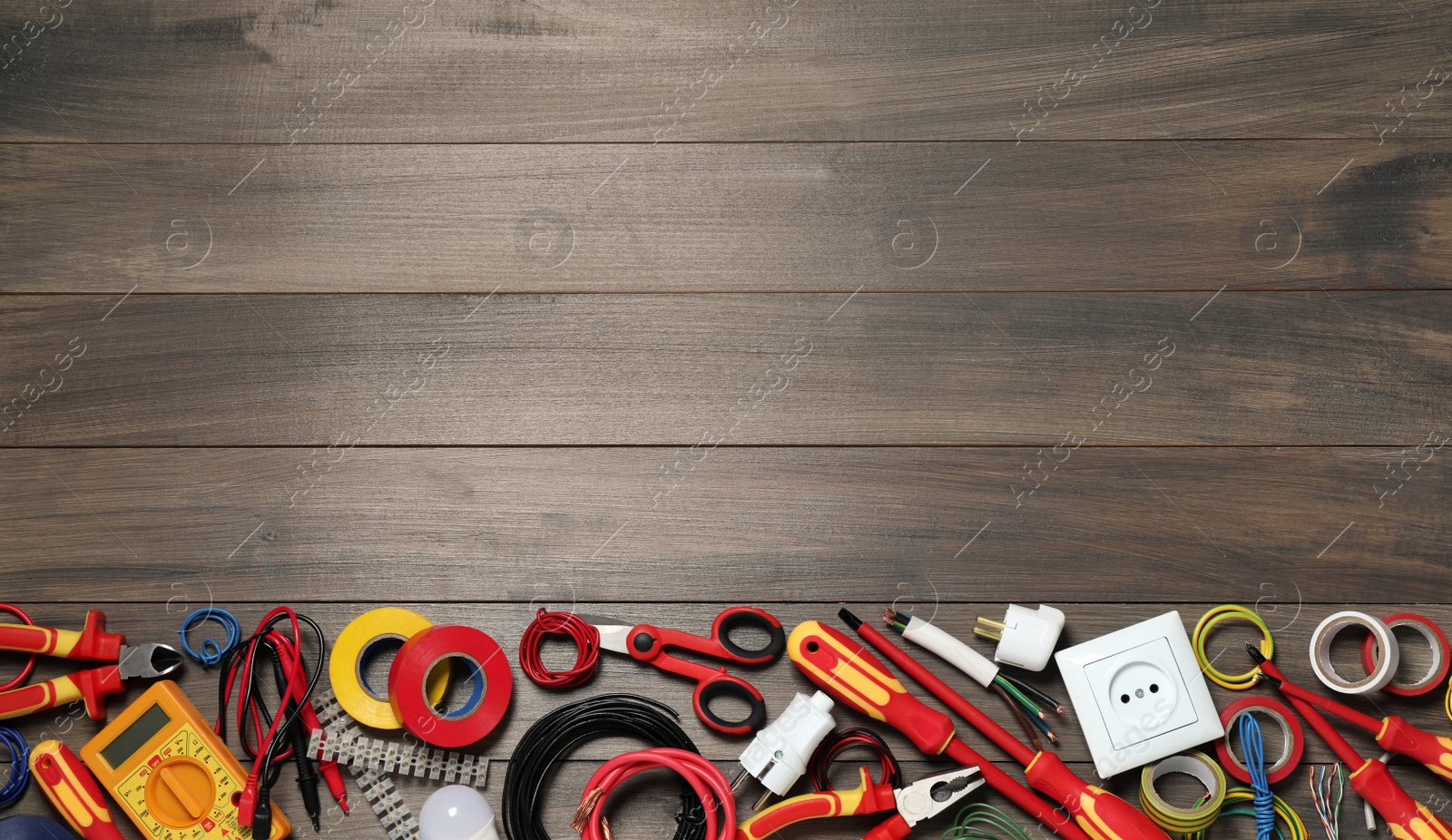 Photo of Set of electrician's tools and accessories on wooden table, flat lay. Space for text