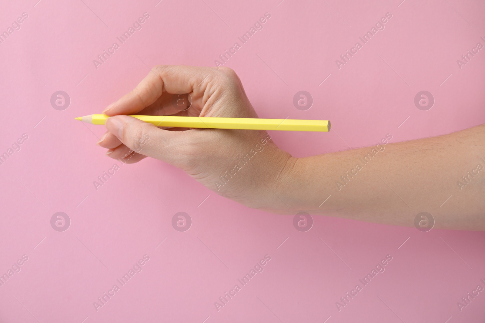 Photo of Woman with yellow pencil on pink background, closeup