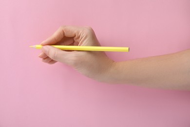 Photo of Woman with yellow pencil on pink background, closeup