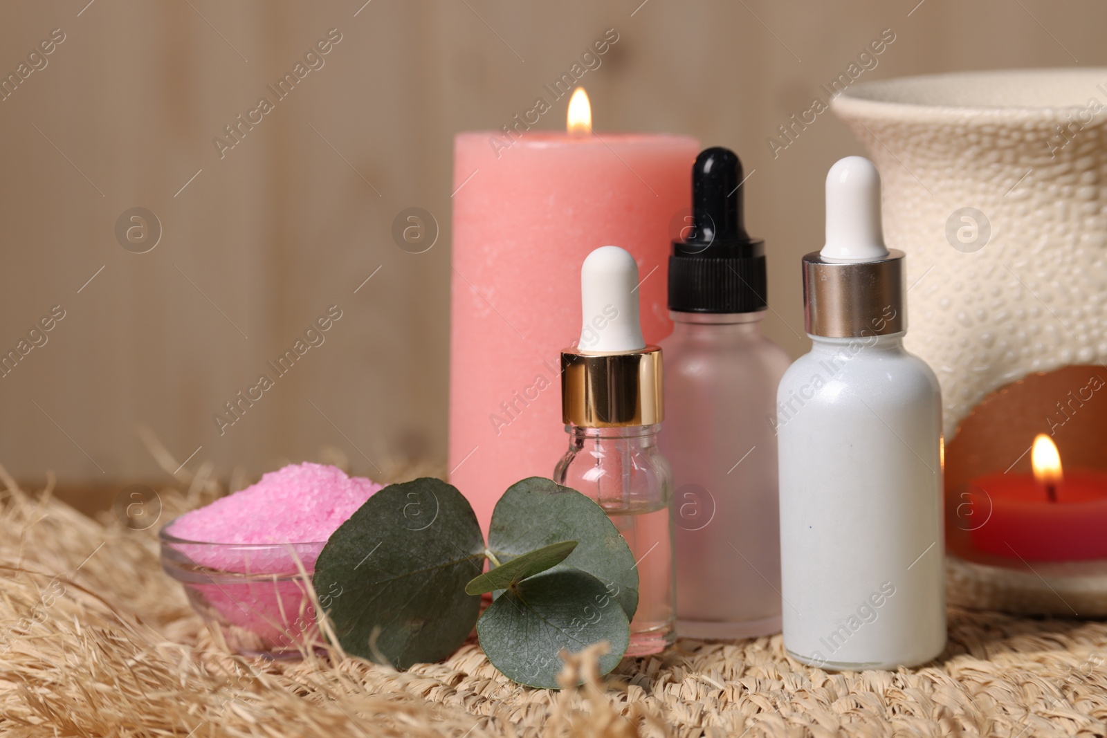 Photo of Different aromatherapy products, burning candles and eucalyptus leaves on table, closeup