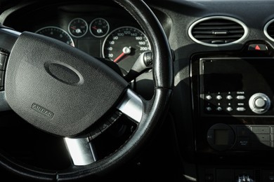 Photo of Black steering wheel and dashboard in car