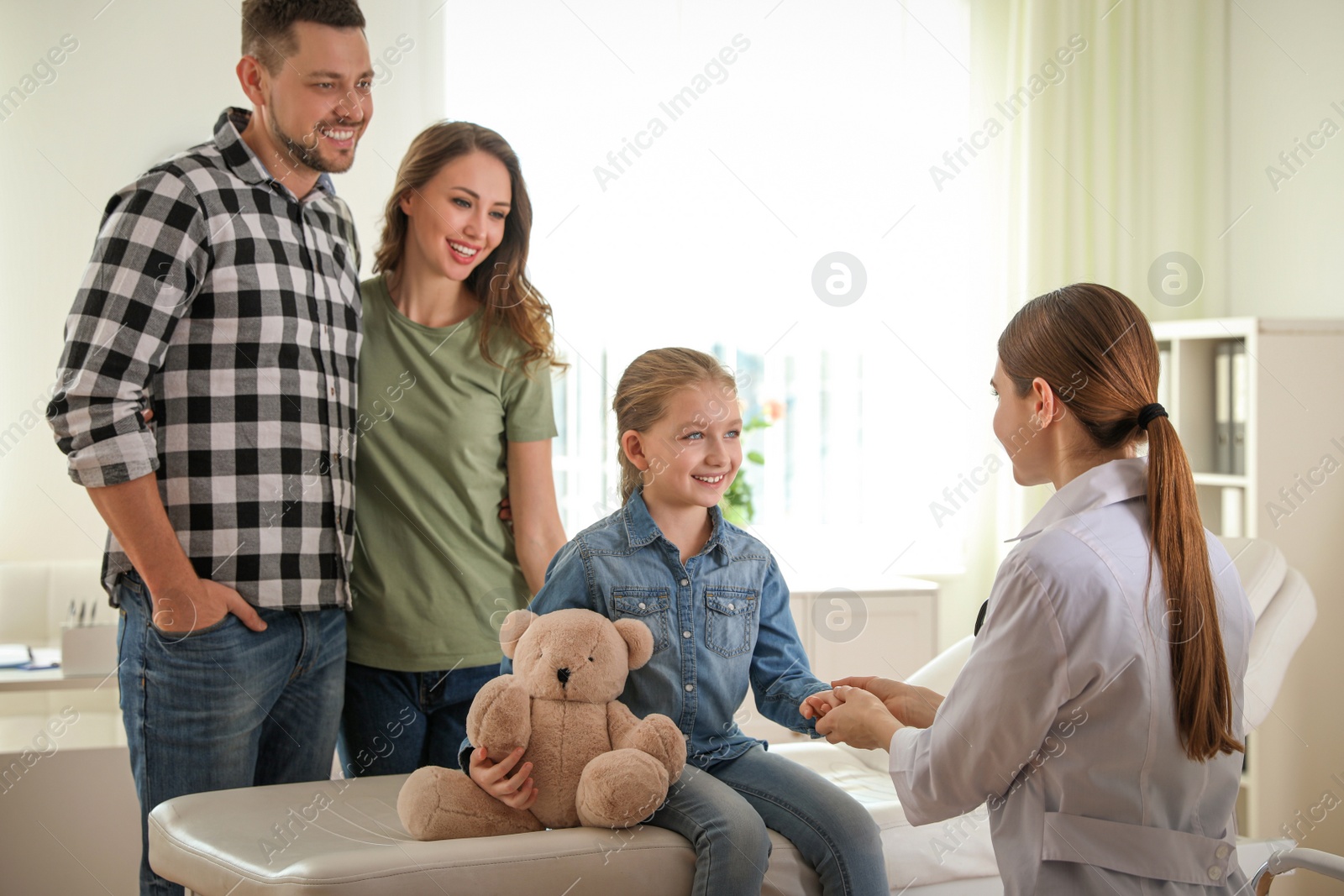 Photo of Parents and daughter visiting pediatrician. Doctor working with patient in hospital