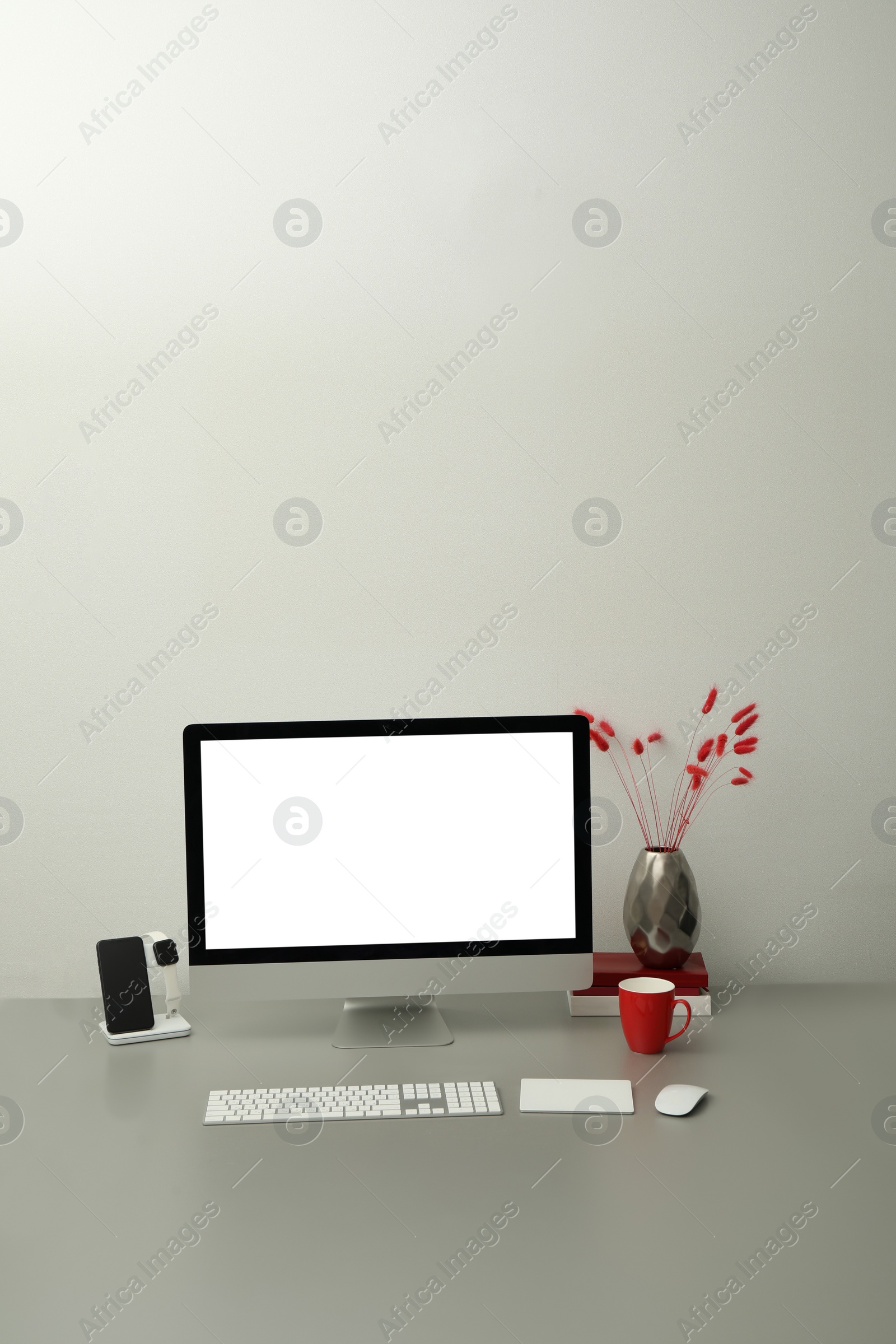 Photo of Modern workplace with computer and charging devices. Interior design