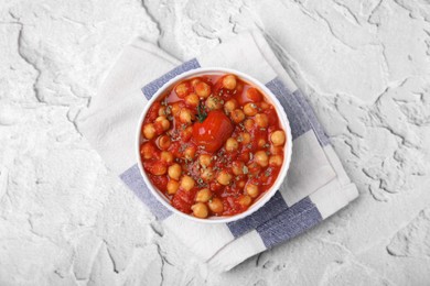 Photo of Delicious chickpea curry in bowl on white textured background, top view