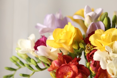 Photo of Beautiful bouquet of spring freesia flowers on blurred background, closeup