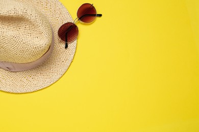 Photo of Hat and sunglasses on yellow background, flat lay with space for text. Sun protection