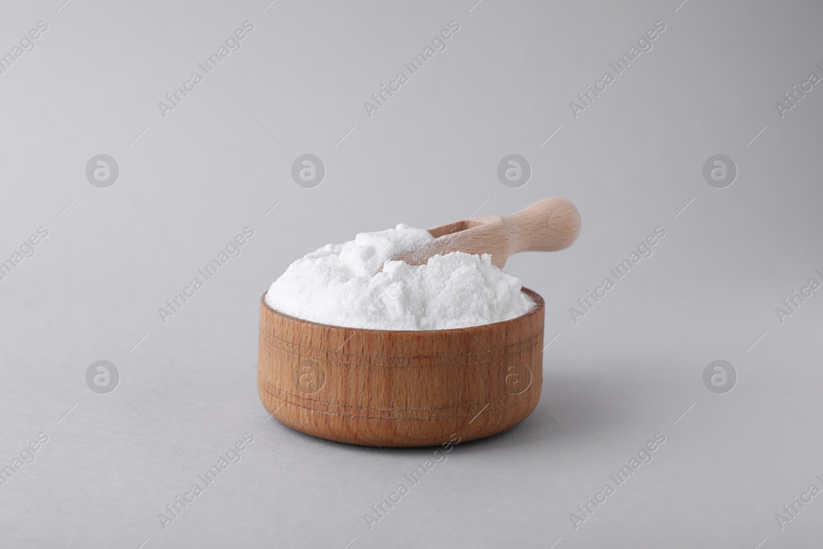 Photo of Bowl with sweet fructose powder and scoop isolated on white