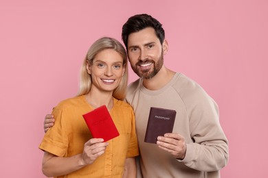 Immigration. Happy couple with passports on pink background