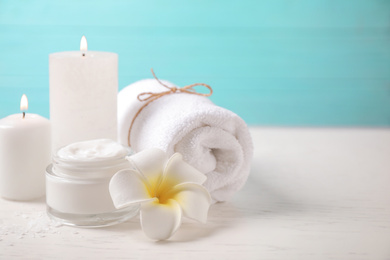 Photo of Composition with cream and burning candles on white wooden table. Spa treatment