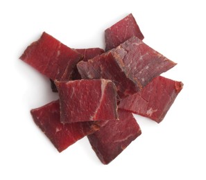 Photo of Pieces of delicious beef jerky on white background, top view