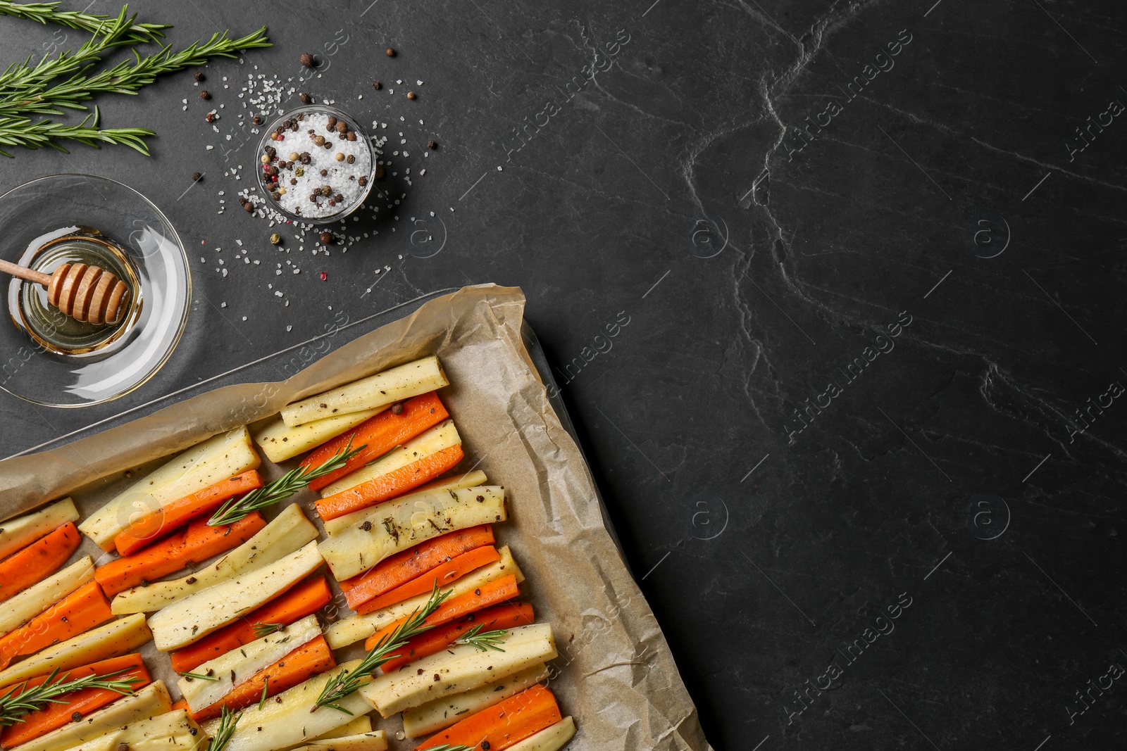 Photo of Tray with parsnips, carrots and other products on black table, flat lay. Space for text