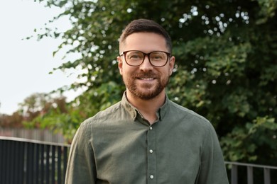 Portrait of handsome bearded man in glasses outdoors