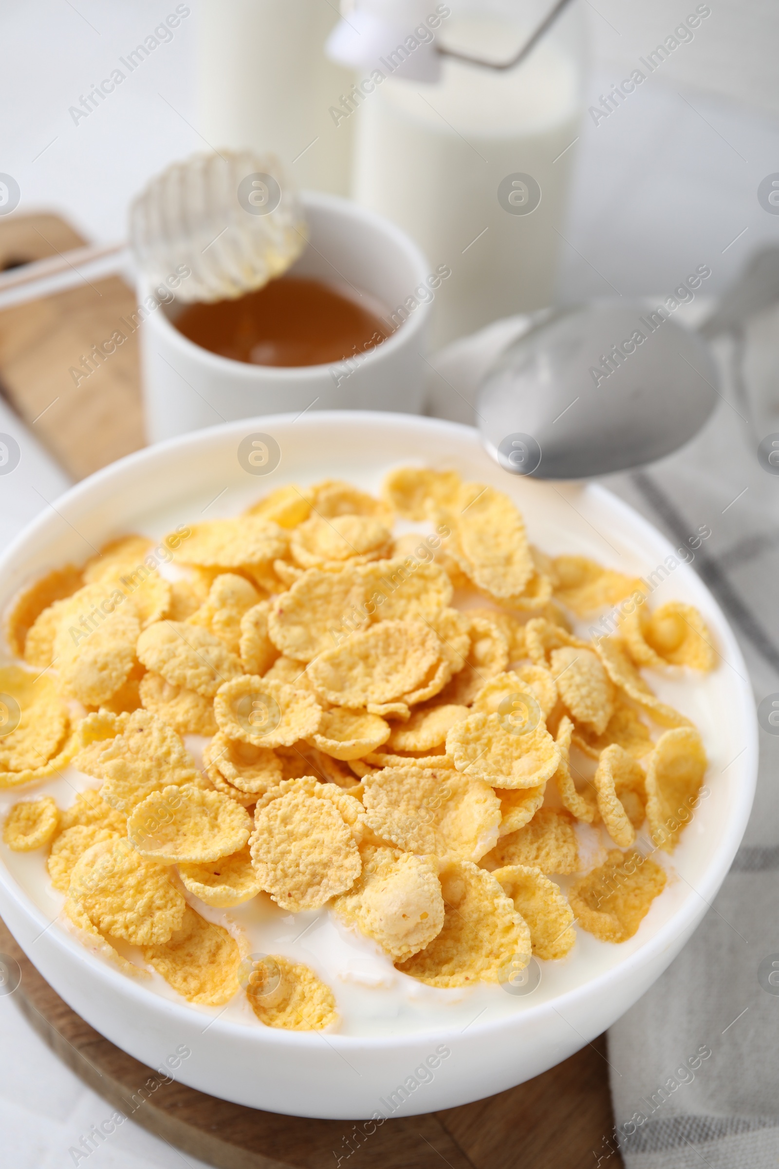 Photo of Breakfast cereal. Tasty corn flakes with milk in bowl on table