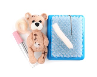 Photo of Needle felted bear, wool and tools isolated on white, top view