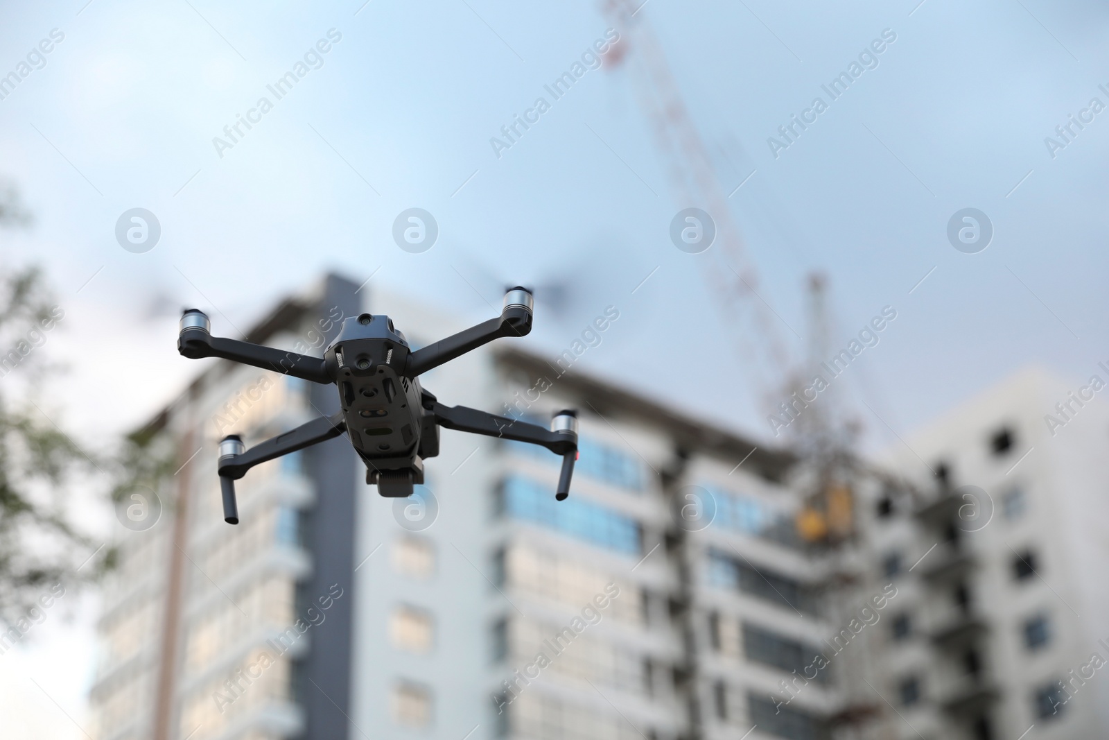 Photo of Modern drone flying at building site. Aerial survey