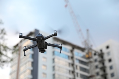 Photo of Modern drone flying at building site. Aerial survey