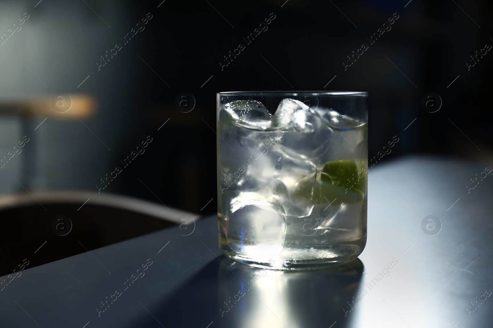 Photo of Glass of delicious cocktail with vodka on counter in bar