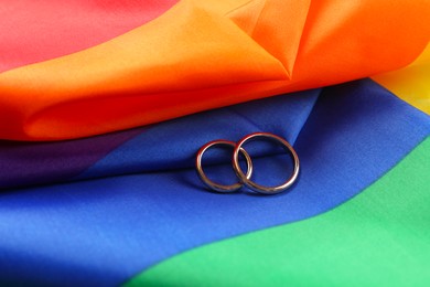 Wedding rings on rainbow LGBT flag, closeup