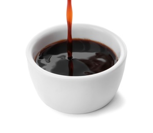 Pouring tasty soy sauce into bowl isolated on white