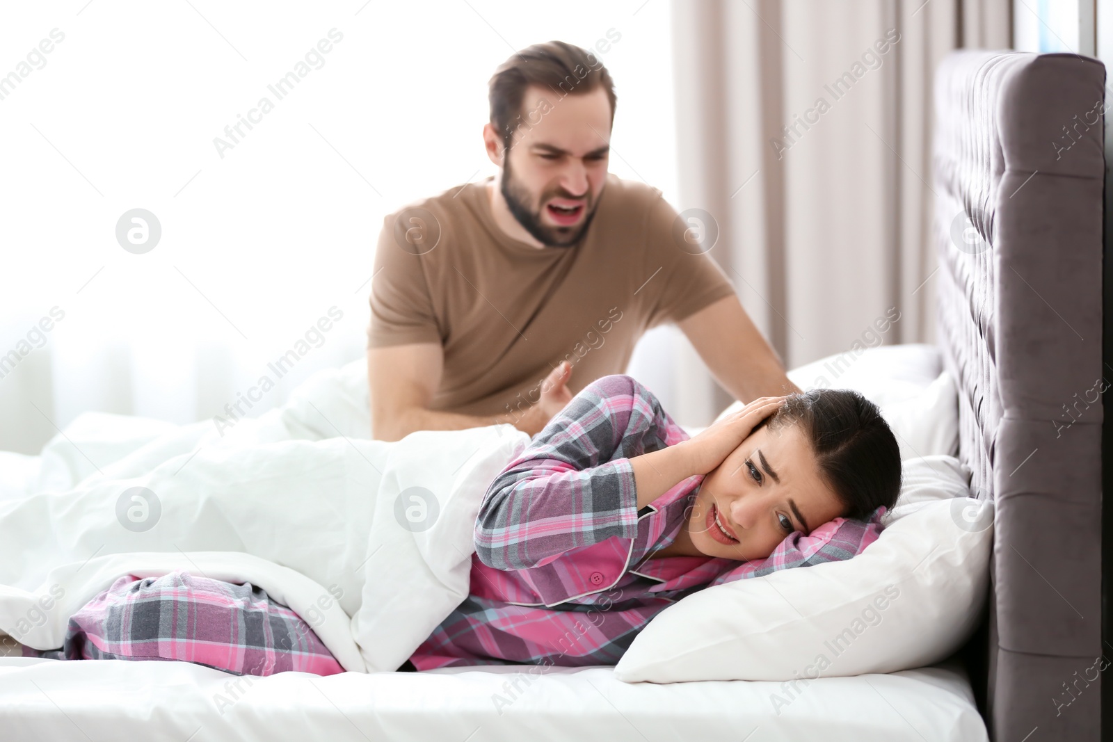 Photo of Young couple having argument in bedroom