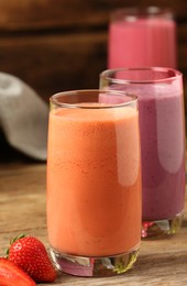 Photo of Glasses with tasty smoothies on wooden table