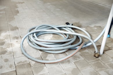 Photo of Grey hose on wet pavement in garden center