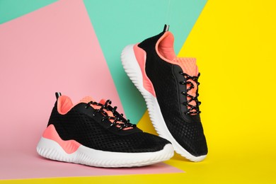 Photo of Pair of stylish sport shoes on color background
