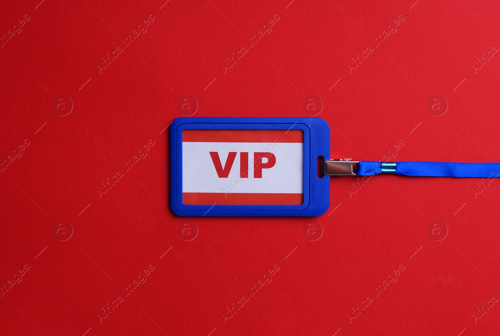 Photo of Plastic vip badge on red background, top view